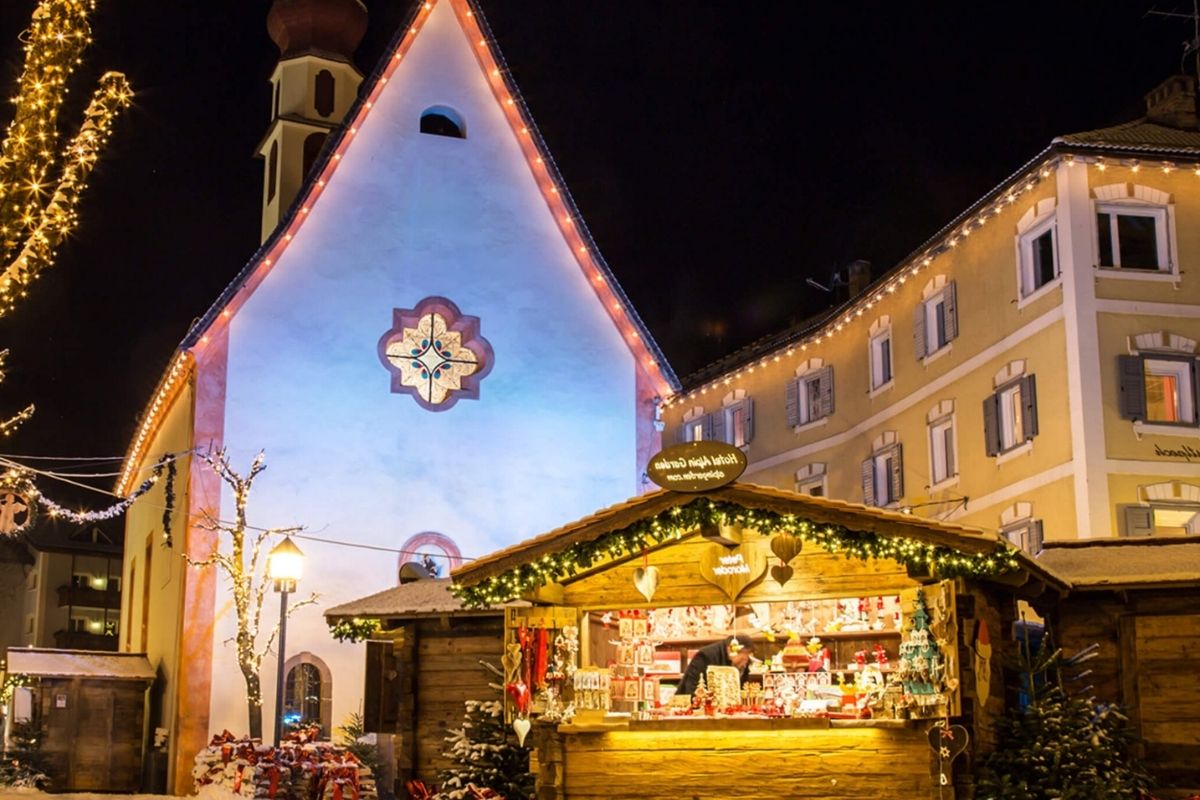 Immagine di un vivace mercatino di Natale a Belluno, con luci e decorazioni festive
