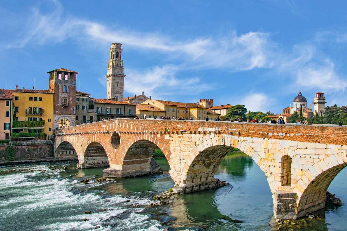 Vista panoramica di Verona con eventi culturali in primo piano, include l'Arena e Casa di Giulietta