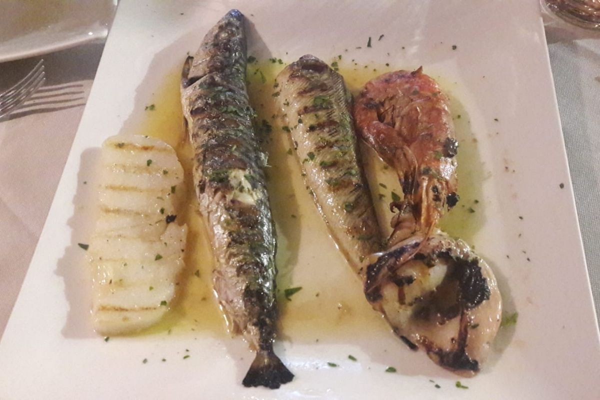 Un tipico piatto di pesce fresco servito in un ristorante di Chioggia